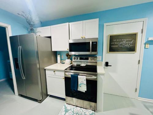 a kitchen with a stove and a refrigerator at Coastal Retreat Near Pineville and CLT in Charlotte