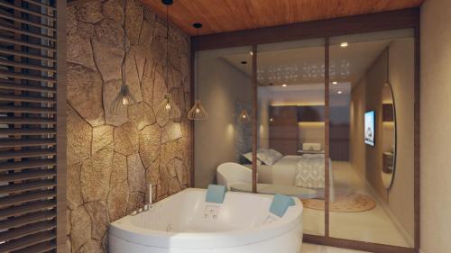 a bathroom with a tub in front of a bedroom at Hotel Rio Guayas by Art Hotels in Guayaquil