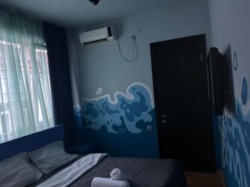 a bedroom with a bed and a blue wall at Porta Hostel in Batumi