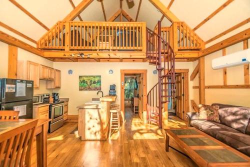 a kitchen and living room with a spiral staircase in a house at Waterfront Prairie Flower Treehouse in Seguin