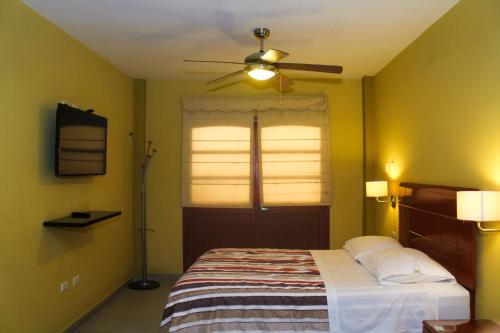 a bedroom with a bed and a ceiling fan at Apart-Hotel El Cañaveral in Chincha