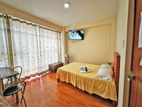 a bedroom with a bed and a television on the wall at hotel el parral suite in Ica