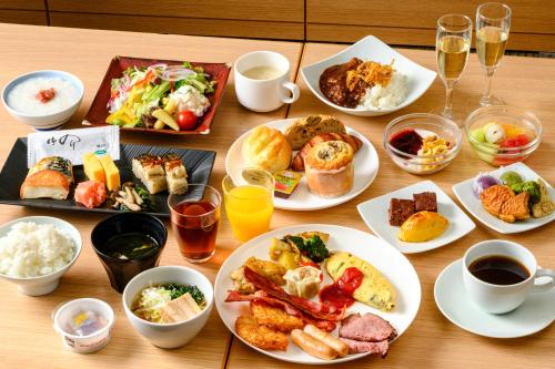 a wooden table with plates of food and drinks at Richmond Hotel Premier Asakusa International in Tokyo
