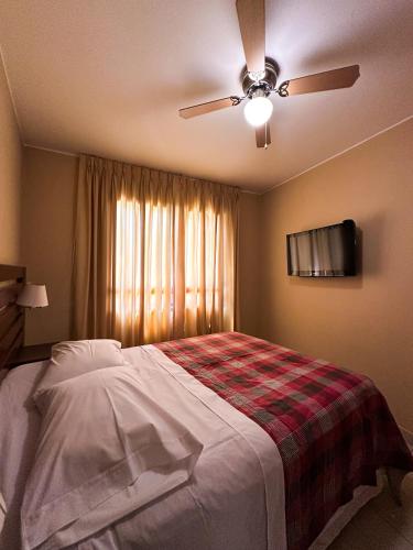 a bedroom with a bed and a ceiling fan at Apart-Hotel El Cañaveral in Chincha