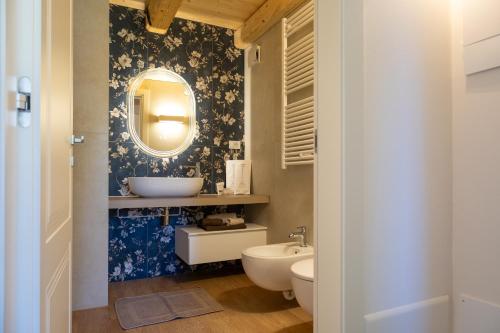 ein Badezimmer mit Waschbecken und Spiegel in der Unterkunft Corte La Pellegrina in Caprino Veronese