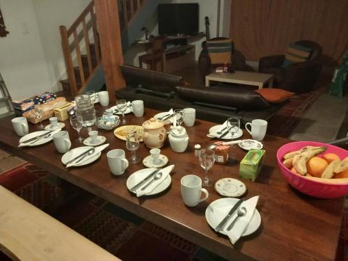 een tafel met borden en bekers en een kom eten bij Via Lactéa in Saint-Goussaud