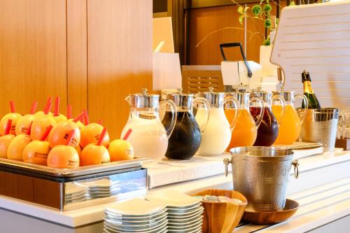 東京にあるリッチモンドホテルプレミア浅草インターナショナルのカウンターに飲み物とオレンジが並んだビュッフェ