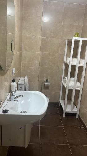 a bathroom with a white sink and a shelf at Baltar in Sanxenxo