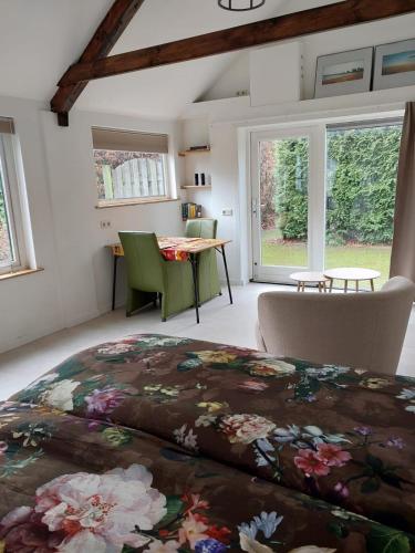 a bedroom with a large bed and a table at Schuurtje bij de IJssel in Terwolde