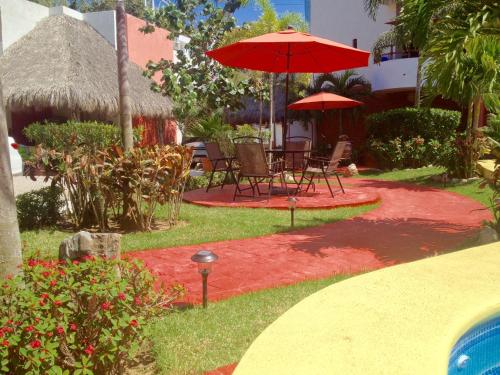 
a garden area with a lawn chair and patio area at Hotel y Suites Los Encantos in Sayulita
