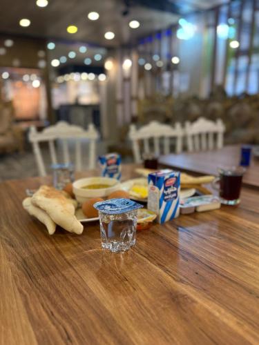 a wooden table with food and drinks on it at Sarko hotel فندق سركو in Baghdad