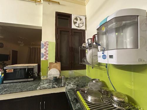 a kitchen with a microwave and a stove top oven at Pearl of Nature By Nyra in New Delhi