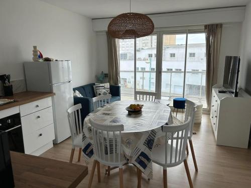 une cuisine et une salle à manger avec une table et des chaises dans l'établissement La roue Bleue, à Saint-Jean-de-Monts