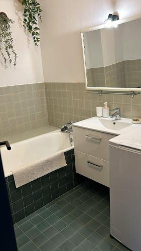 une salle de bain avec une baignoire, un lavabo et un miroir dans l'établissement La roue Bleue, à Saint-Jean-de-Monts
