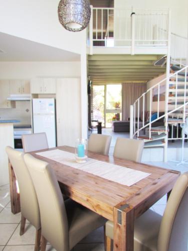 a dining room with a wooden table and chairs at Shelly Beach Resort in Port Macquarie