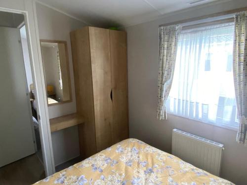 a small bedroom with a bed and a window at AMC Flamingo Land Caravan, Motorhome & Campervan Hire in Kirby Misperton