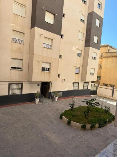 a large building with a courtyard in front of it at Apartment béni messous 1 in Ouled Beni Messous