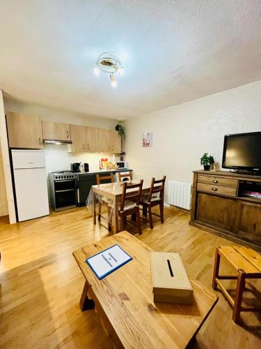 un salon avec une table et une cuisine dans l'établissement Appartement Allemond 6 personnes, à Allemont