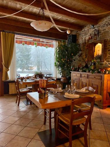 a dining room with tables and chairs and a kitchen at Hotel della valle in Vernante