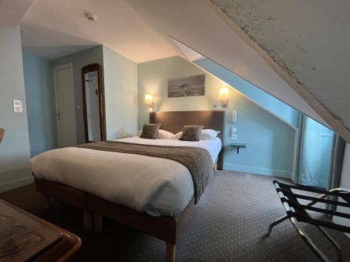 a bedroom with a large bed with an attic at Hotel des Abers in Saint Malo