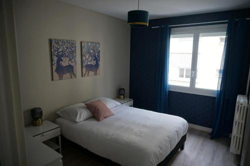 une chambre avec un grand lit blanc et une fenêtre dans l'établissement Appartement confortable, à Caen