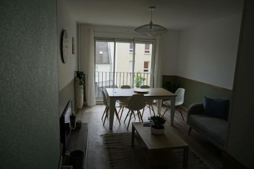 un salon avec une table et un canapé dans l'établissement Appartement confortable, à Caen