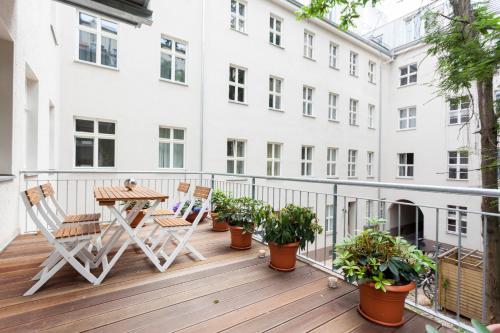einen Balkon mit einem Tisch, Stühlen und Pflanzen in der Unterkunft GreatStay Apartment - Torstraße in Berlin