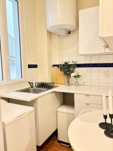 une cuisine blanche avec un évier et une fenêtre dans l'établissement 4 Guests Apt Jardin des Plantes, à Paris