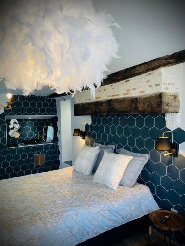 - une chambre bleue avec un lit et des oreillers blancs dans l'établissement Le Family Pop-Art, à Montaigu-le-Blin