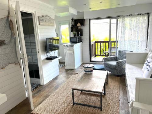 un salon avec un canapé et une table dans l'établissement Deauville - appartement avec terrasse face à l'Hippodrome, à Deauville