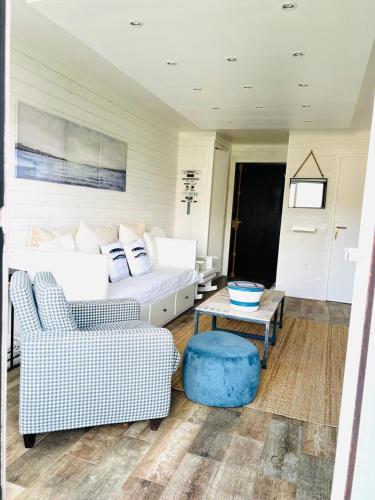 un salon avec un canapé et deux chaises dans l'établissement Deauville - appartement avec terrasse face à l'Hippodrome, à Deauville