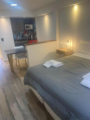 a bedroom with a bed and a table and a desk at Departamento 105 - Edificio VILAUT by INMOVE Temporarios in Córdoba