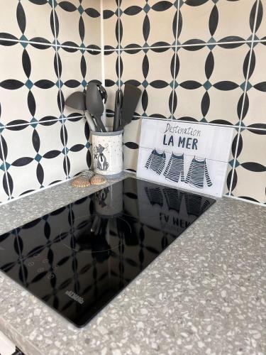 un comptoir de cuisine avec un mur noir et blanc à motifs dans l'établissement Deauville - appartement avec terrasse face à l'Hippodrome, à Deauville