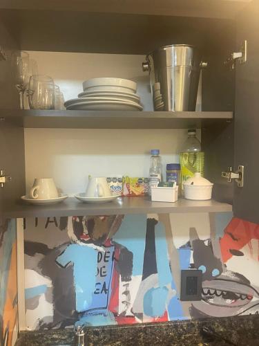 a shelf with plates and dishes in a kitchen at Departamento 105 - Edificio VILAUT by INMOVE Temporarios in Córdoba
