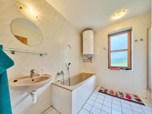a bathroom with a sink and a tub and a window at Holiday Home Stárkov by Interhome in Stárkov