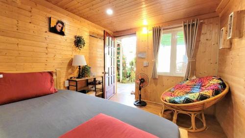 a bedroom with a bed and a chair and a window at Triệu đoá hồng-Nhà Xinh Rosé in Ấp Ða Lợi