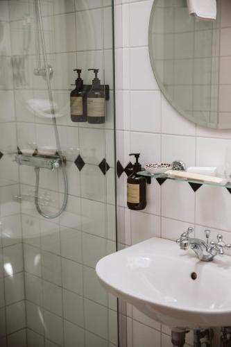 a bathroom with a sink and a shower at Köpmans Boutique Hotel & Bistro in Höganäs