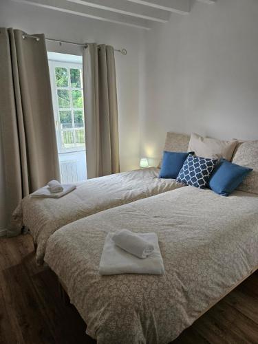 ein Schlafzimmer mit zwei Betten mit Handtüchern darauf in der Unterkunft Holy Cottage in Sainpuits