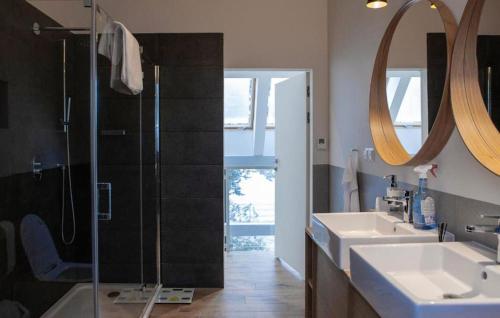 a bathroom with two sinks and a glass shower at Gorgeous Home In Kowalewo With Wifi in Kowalewo