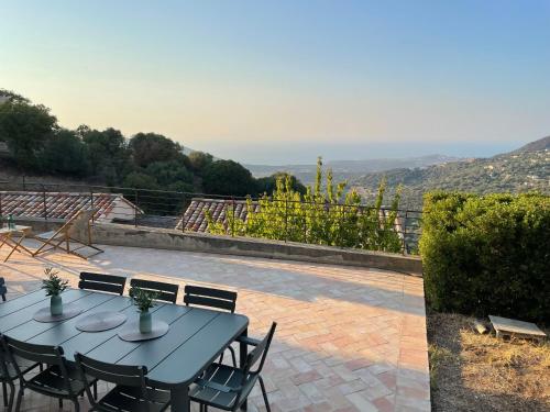 une table et des chaises sur une terrasse avec vue dans l'établissement Villa vue imprenable mer et montagne, à Cateri