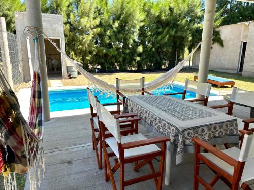 a patio with a hammock and chairs and a pool at Casa Quinta Los Arandanos in San Geronimo