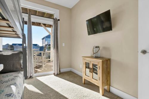 a bedroom with a bed and a tv on a wall at Ocean Air Entire by Sea Scape Properties in Surf City