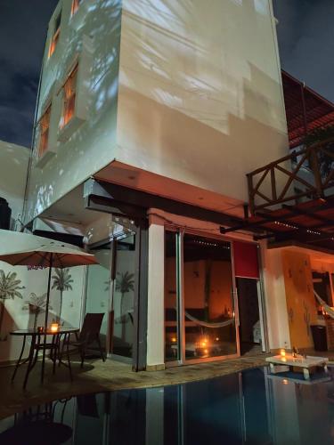 a building with a pool and a table and an umbrella at Cancún Hotel Boutique & Hostel in Cancún