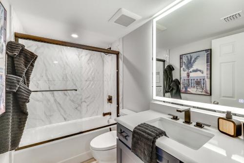 Un baño con lavabo, inodoro y espejo. en Luxury Sanibel Condo with Ocean View Steps to Beach, en Sanibel
