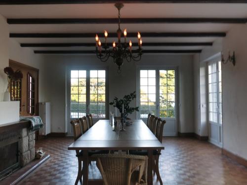 une salle à manger avec une table, des chaises et un lustre dans l'établissement MaisonPortManech - exquisites Kleinod in der Bretagne, à Névez