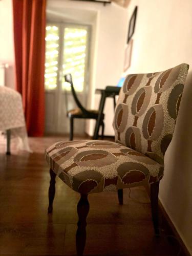 a chair sitting in a living room next to a window at postAielli - Arte, Natura e Relax in Aielli
