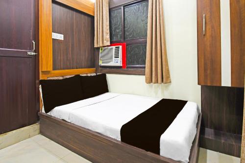 ダンバードにあるHotel O Atithi Restro And Cafeの窓のある部屋にある小さなベッド