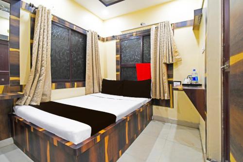 a small bedroom with a bed in a room at Hotel O Atithi Restro And Cafe in Dhanbād