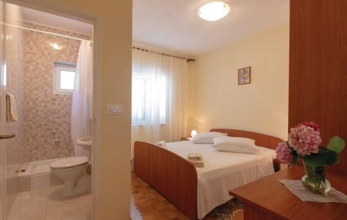 ein Schlafzimmer mit einem Bett und ein Badezimmer mit einer Toilette in der Unterkunft Apartments Zdravko in Orebić