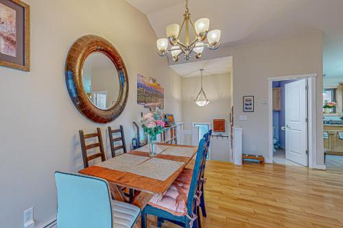 a dining room with a table and a mirror at Mill Run 2E in Quechee
